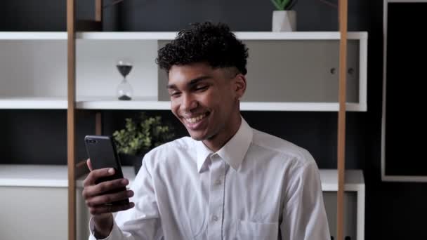 Amichevole uomo afroamericano che parla al telefono con i partner — Video Stock