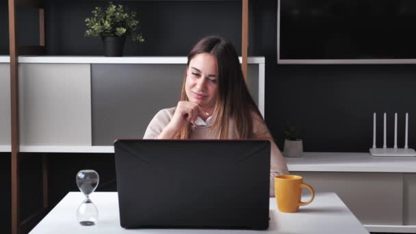 Milenial mujer sentada en la oficina moderna utiliza portátil frotar la barbilla escribiendo el texto 4k — Vídeos de Stock