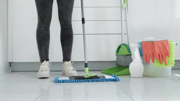 Vista de pés femininos, mulher com chão de limpeza esfregona na cozinha. Conceito de limpeza da casa 4k — Vídeo de Stock