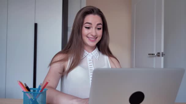 Euforisk ung student kvinnliga vinnare tittar på bärbar dator firar online framgång sitter hemma. Spännande kvinna får goda nyheter, passerar poäng känns motiverade 4k — Stockvideo