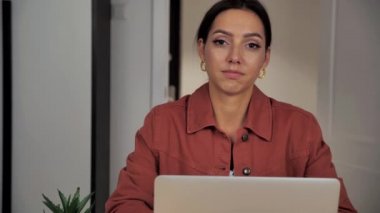 Güzel, kendine güvenen genç, güzel bir kadın. Ofiste yalnız poz veren kameraya bakıyor. Mutlu milenyum öğrencisi profesyonel öğrenci.