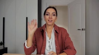 Kendine güvenen esmer kadın kameraya bak, kameraya bak, kamerayla konuş video konferansı yap iş görüşmesi yap 4K 'de internet üzerinden Webinar sunumu yap