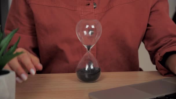 Frauenhände drehen die Sanduhr auf dem Schreibtisch. Erfolgskonzept 4k — Stockvideo