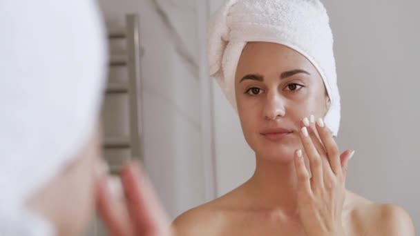 얼굴을 극도로 가까이 하는 여성의 피부 관리. 크림 을 바르는 매력적 인 여인 - 변소에서 4k — 비디오