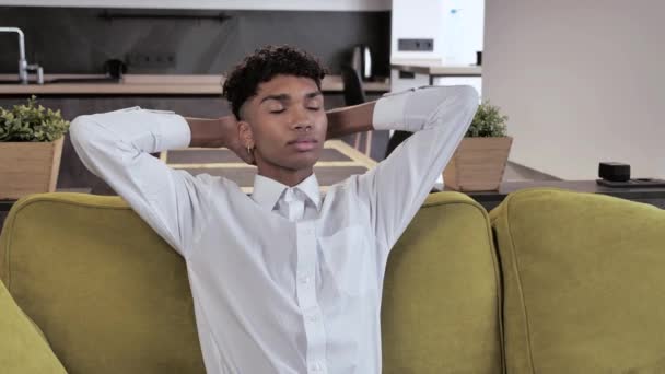 Atrakcyjne zdrowe spokojny młody afro człowiek w białej koszuli relaks na wygodnej kanapie drzemki czuć stres wolny w domu salon sam 4k — Wideo stockowe