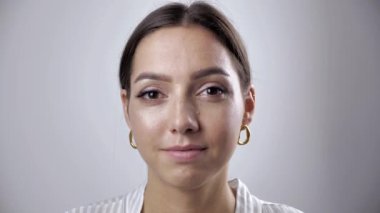 Çekici, kendine güvenen, güzel bir kadın. Stüdyoda yalnız poz veren kameraya bakıyor. Mutlu bir milenyum heykeli.