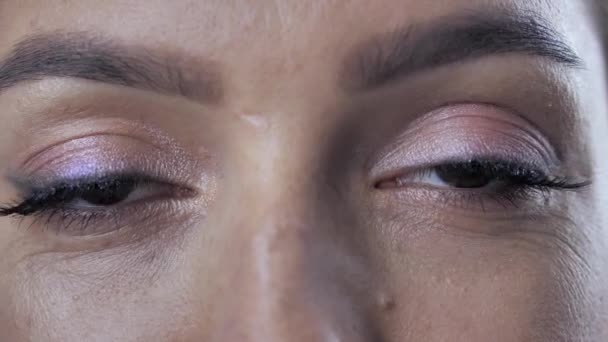 Ženské blikající oči s krásnou hnědou. Detailní záběr dvou ženských očí s pohyblivými zornicemi a přirozenými dlouhými řasami. Lidské oči jako neuvěřitelně složitý orgán. Zpomalený filmový snímek — Stock video