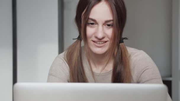 Cute 20s lady working at desk in trendy hipster start up office using shared data. Pretty face close up with emotion of joy and happy success. Student writing a report on successful marketing — Stock Video