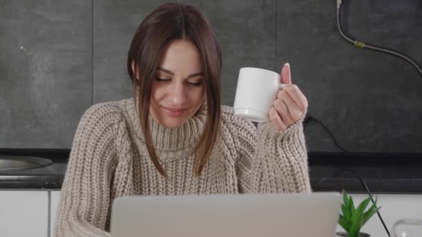 Gelukkig jong vrouw lachen om grappige streaming film op laptop of is in correspondentie thuis het drinken van koffie plezier alleen — Stockvideo