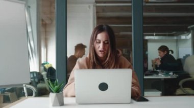 Sweatshirt giymiş bir kadın iş yerinde büyük sorunlar yaşadı. Stres yaşadı. Kafasında ani bir ağrı oluştu. Kafa masajı yapıyor.