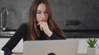 Evde dizüstü bilgisayarla çalışırken cep telefonuyla konuşan yaşlı bir kadın. Ciddi bir iş kadınının portresi telefon görüşmesi yapıyor ve evde bilgisayar mesafesinde çalışıyor.