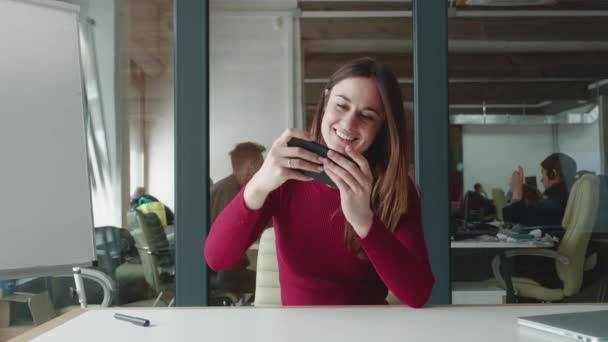 Ung attraktiv kvinna hipster spelar mobilspel och förlorar. Kaukasiska kvinna fokusera på att slå sin motståndare och förlora när du spelar sitt spel, mycket upprörd med kontor bakgrund. — Stockvideo