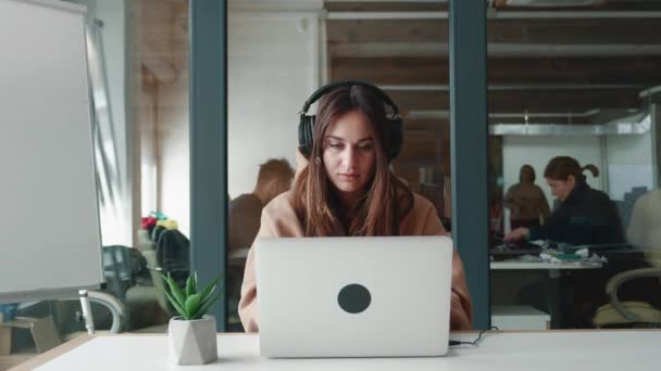 Портрет щасливої жінки бізнесменки молодий студент в навушниках дивиться на екран ноутбука, читає хороші новини, радіє успіху, відзначає перемогу, вітає так, дізнається про роботу, концепцію тріумфу — стокове відео