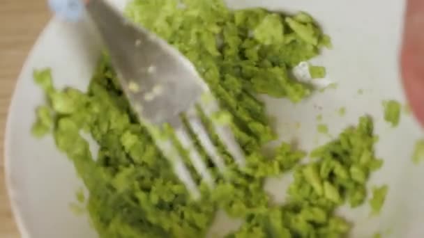 Avocado met een vork in de kom slaan. Het bereiden van vegetarische avocado saus. Gezond voedsel koken. Voeding om gewicht te verliezen — Stockvideo