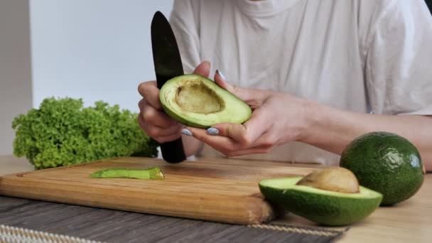 Kvinnliga händer rengör skorpan avokado. Färsk mogen avokado, Friska frukost, Vegetarisk mat — Stockvideo