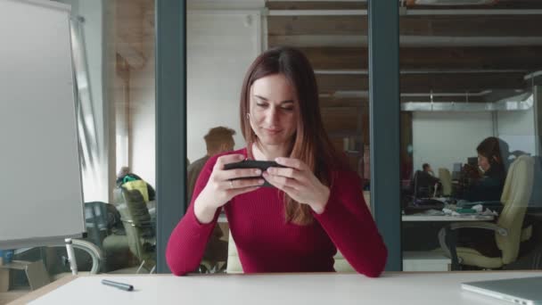 Ung attraktiv kvinna hipster spelar mobilspel och förlorar. Kaukasiska kvinna fokusera på att slå sin motståndare och förlora när du spelar sitt spel, mycket upprörd med kontor bakgrund. — Stockvideo