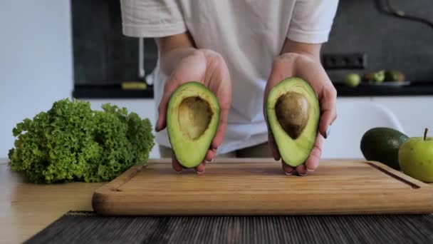 Manos femeninas sosteniendo aguacate. Concepto de estilo de vida saludable — Vídeos de Stock