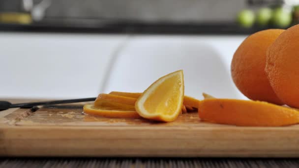 Жіночі руки з ножем, що ріже апельсин на обробній дошці — стокове відео