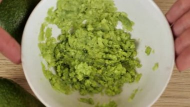 Erkek aşçı avokadoyu kasede eziyor. Meksika usulü vejetaryen avokado soslu avokado sosu, avokado tostu, tortilla sosu ve hamburger sosu yapmak için sağlıklı bir ziyafet.