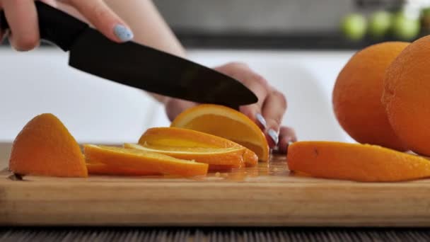 Extra close-up vrouwenhanden gesneden oranje. Sinaasappel gesneden op hout het bord. Dieet, weinig calorieën, vegetarisme, natuurlijke vitaminen. — Stockvideo