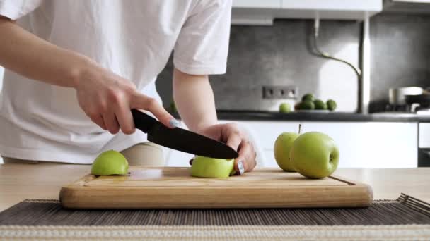 Manos de mujer con un cuchillo cortando manzana en la tabla de cortar — Vídeos de Stock