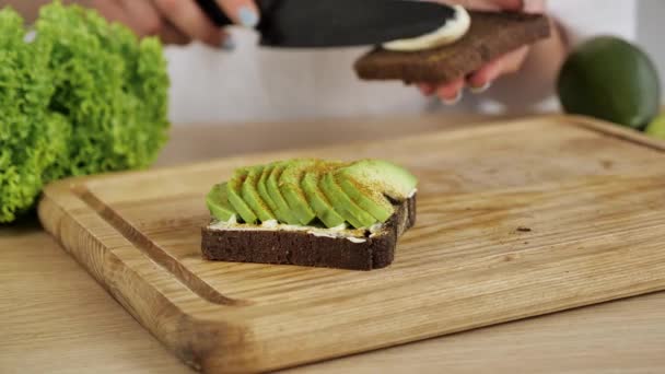 Toast de seigle sain avec tranches d'avocat sur planche de bois — Video