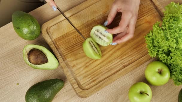 De kok snijdt stukken van een kiwi. Koken schieten. — Stockvideo