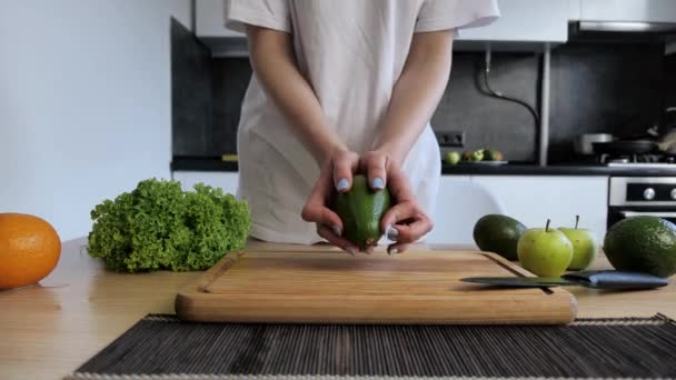 Chef donna che mostra le mani avocado fresco in interni della cucina moderna. Concezione cibo vegano sano — Video Stock