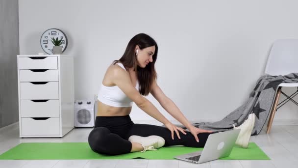 Atraktivní Flexibilní žena učení jóga on-line pomocí notebooku, bezdrátové sluchátka sledování výuky na internetu — Stock video