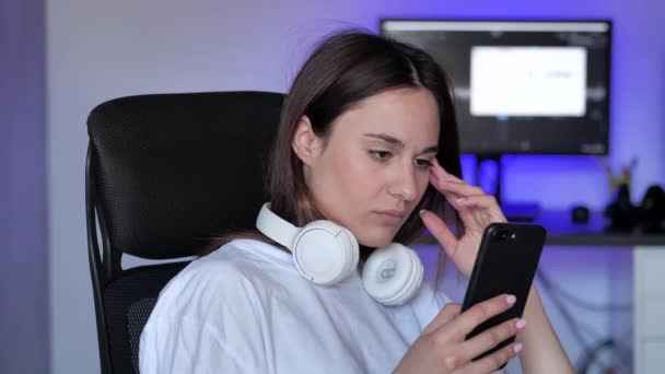 Mujer joven preocupada leyendo malas noticias en el mensaje en el teléfono inteligente. Problemas de relación — Vídeos de Stock