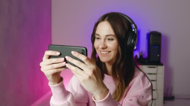 Γυναίκα παιχνίδι αναπαραγωγή με θηλυκό smartphone wining και δείχνουν χειρονομία ναι. Επιτυχής ιδέα — Αρχείο Βίντεο