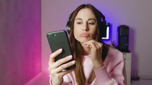 Inquiet jeune femme tenant téléphone sentiment de jalousie anxiété en attente d'appel mobile assis seul à la maison, réfléchi dame douteuse stressée regardant smartphone penser à tromper petit ami 4k — Video