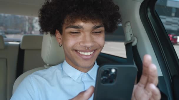 Κοντινό πλάνο τύπος πληκτρολογώντας το κινητό τηλέφωνο στο αυτοκίνητο. Αφρο-Αμερικανός επιχειρηματίας chatting smartphone, ο τύπος κάνει μια online αγορά — Αρχείο Βίντεο