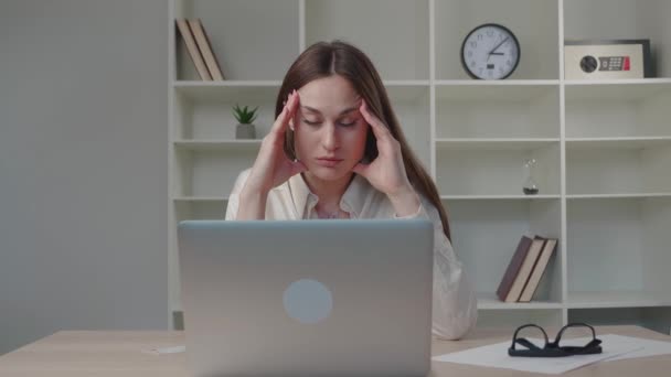 Подбитая стрессом молодая женщина в рубашке, глядя на экран ноутбука, испытывает неприятное удивление, изумленная девушка, пользующаяся компьютером для чтения шокирующих онлайн-новостей, пишет техническую поддержку компьютерной проблемы — стоковое видео
