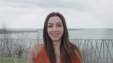 Dışardaki genç bayanın portresini kapat. Saçları rüzgarda dalgalanan bir kadın.