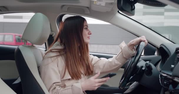 Τηλεφωνικό μήνυμα, χαρούμενη νεαρή γυναίκα που κάθεται στο αυτοκίνητο — Αρχείο Βίντεο