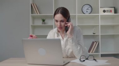 Kıdemli bir bayan yöneticiyle astının iş görüşmesi. Ofisin arka planına karşı yeni bir iş stratejisi tartışması