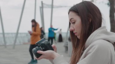 Park arka planında kamera olan kadın.