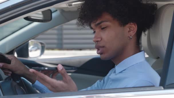 Счастливая афро-американская миллениальная запись голосового сообщения на смартфоне в современном автомобиле. — стоковое видео