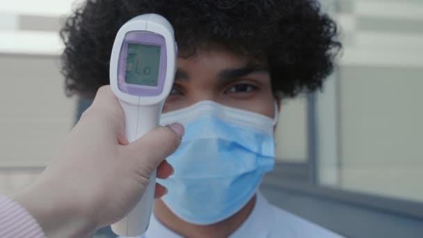 Patiënt Afro-Amerikaanse man gezicht en arts hand met thermometer controle temperatuur — Stockvideo