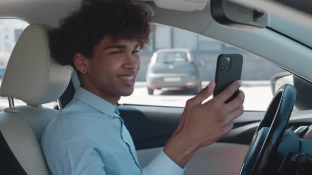 Elegante joven afroamericano hablando en el coche en video a través de teléfono inteligente — Vídeo de stock