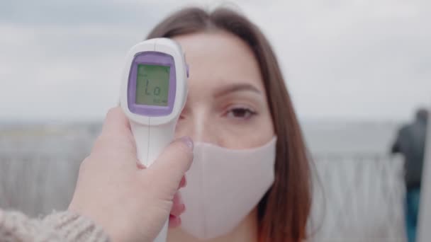 Paciente hermosa cara de mujer y mano de médico con termómetro comprobar la temperatura — Vídeo de stock