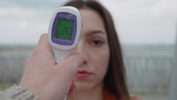 Paciente hermosa cara de mujer y mano de médico con termómetro comprobar la temperatura — Vídeo de stock