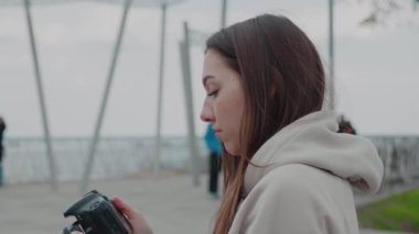 Park arka planında kamera olan kadın.