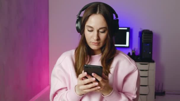 Νεαρή καυκάσια γυναίκα Pro Gamer κερδίζει το παιχνίδι γυναίκα χρησιμοποιώντας Smartphone γιορτάζει την επιτυχία — Αρχείο Βίντεο