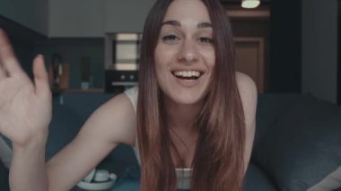 Gülümseyen, el sallayan, video sohbet eden, kahkahalarla gülen, online sohbetin tadını çıkaran neşeli, blog yazarı, kamera kaydına konuşan genç bir kadın.