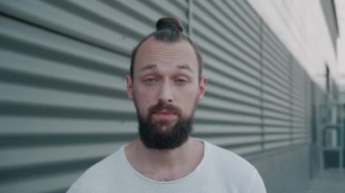 Şok olmuş harika bir adam arka planda kameraya bakıyor.