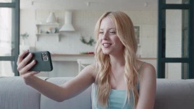 Akıllı telefondan web kamerasına el sallayan genç ve çekici sarışınlar görüntülü sohbet konferansına katılıyor. Sosyal uzaklık partisinin keyfini çıkarıyorlar.