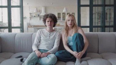 Milenyum sarışını kız ve hippi çocuk kanepede oturur, evde TV izler mutlu hisseder futbol takımı zaferi coşkulu arkadaşlar çığlık atar heyecanlı eller kaldırır ve sarılır ya da piyangoyu kazanır.