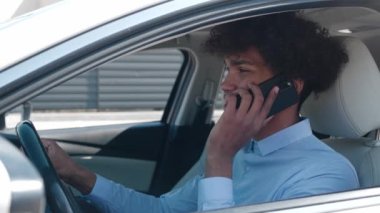 Çekici afro-amerikan genç işadamı araba tebessümünde telefonla konuşuyor direksiyonda oturuyor genç araç açık yolcu koltuğu otomobil sokağı otomobil işadamı ceketi satın alıyor yavaş çekimde yakın çekim